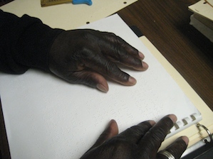 Photo of hands reading a Braille book
