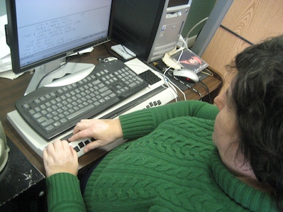 Photo of Deborah Barnes typing Braille on her computer.